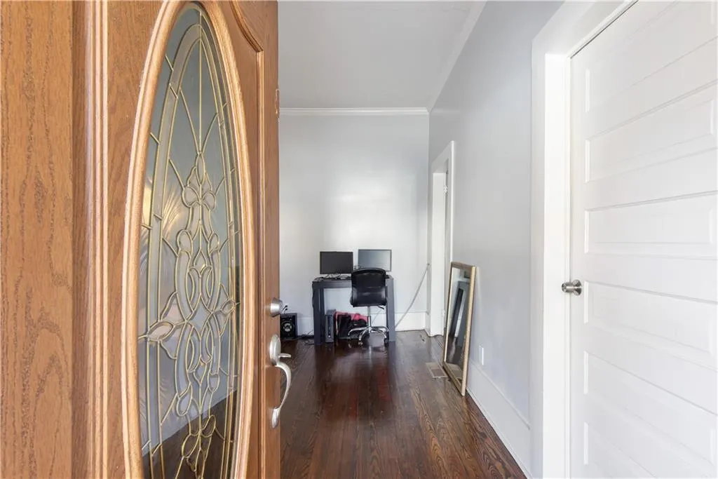 Hall with crown molding and dark hardwood / wood-style floors