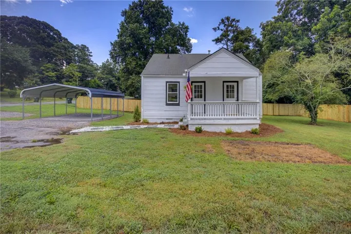 White exterior with a covered porch featuring white railings