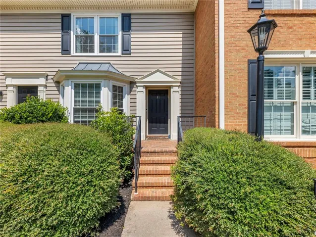 Brick steps leading to a dark entry door with decorative trim