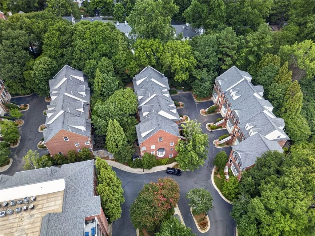 Community of brick townhomes featuring individual balconies and mature tree landscaping