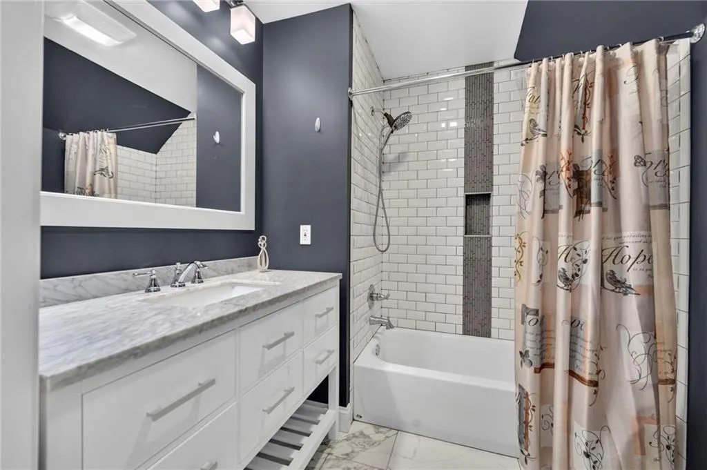 Bathroom featuring a white subway tile shower with a mosaic accent strip and recessed niche