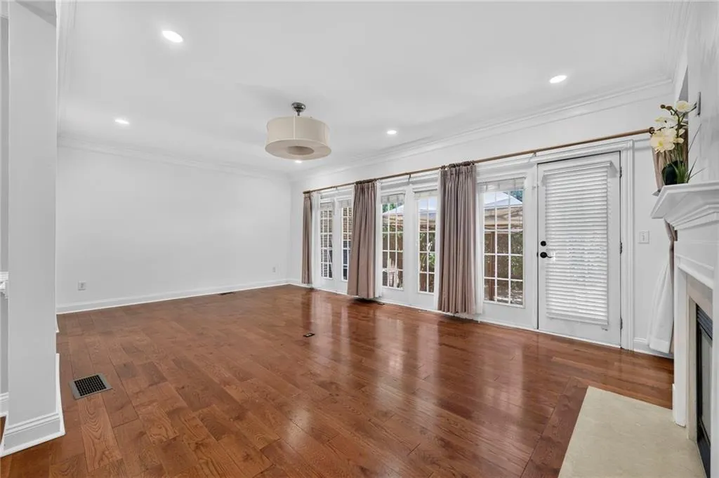 Spacious living area featuring wood-finish flooring, recessed lighting, and a decorative ceiling fixture