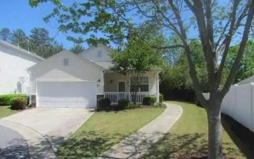 Single-story residence featuring a front-facing garage and a covered porch with white railings
