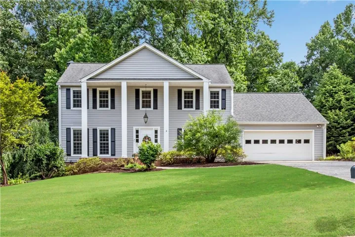 Two-story residence featuring light gray siding, white trim, and black louvered shutters