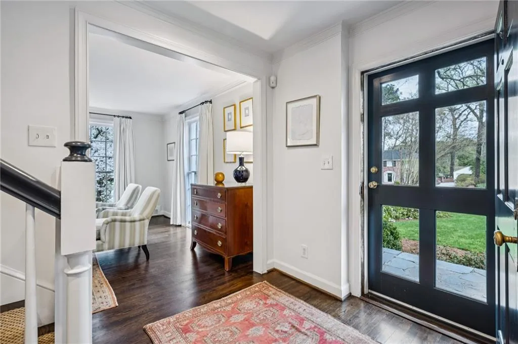 Foyer entrance with dark wood-type flooring and ornamental molding
