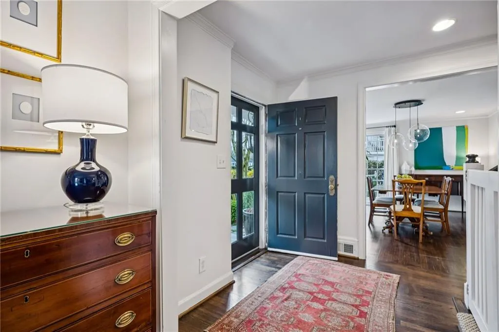 Foyer entrance featuring ornamental molding and dark wood-type flooring