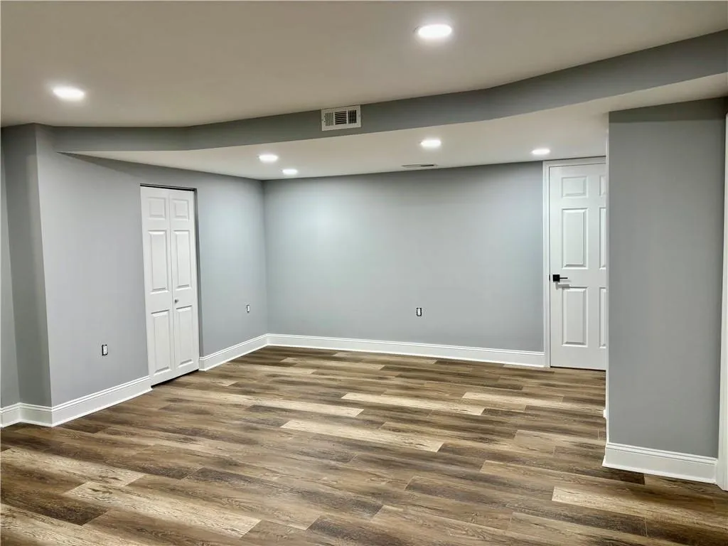 Finished basement featuring baseboards, dark wood-style flooring, and recessed lighting