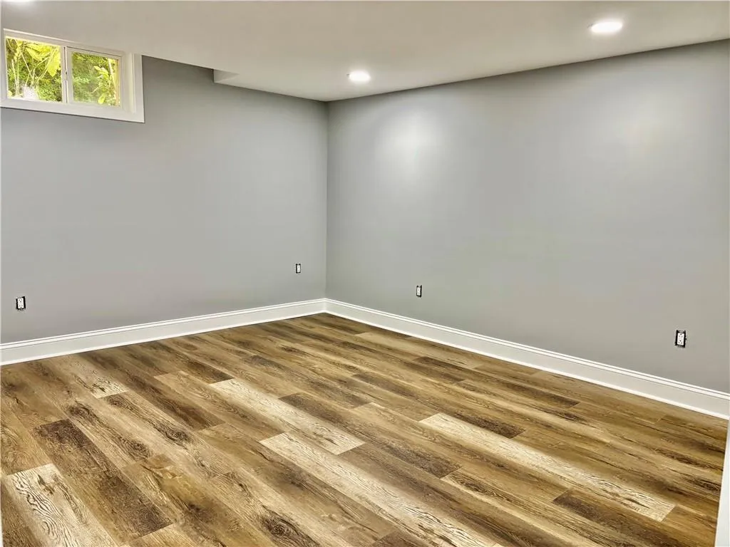 Basement featuring dark wood finished floors, baseboards, and recessed lighting