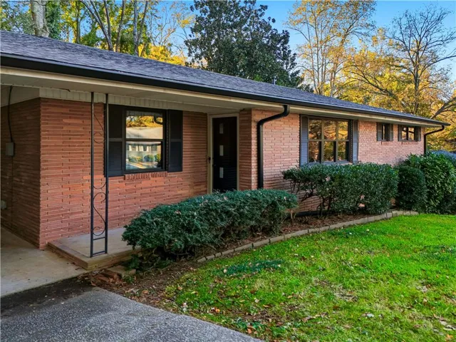 View of front of property featuring a front lawn and brick siding