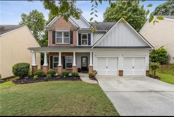 Brick and siding exterior with a covered front porch, dual-pane windows, and a two-car garage