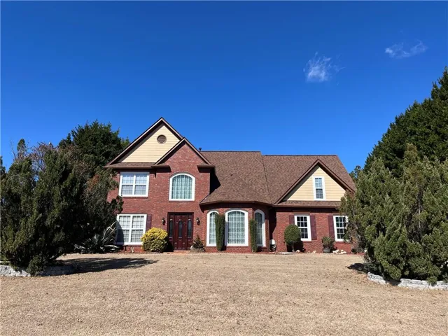 Traditional home with brick siding and a front lawn