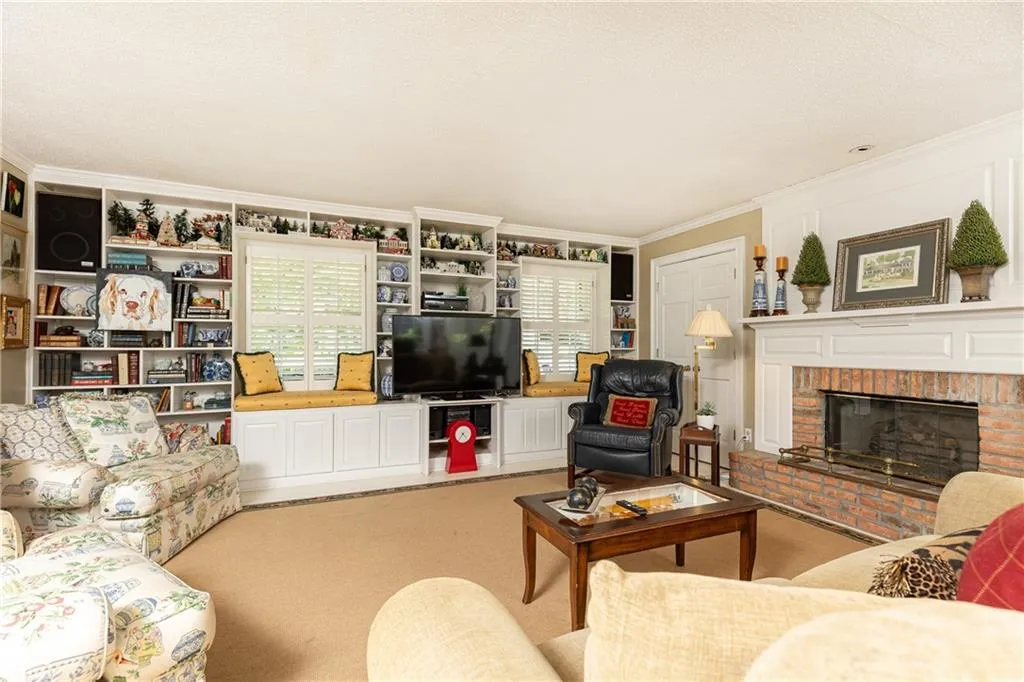 Spacious family room with a full wall of built-in cabinets and shelves, as well as a stately gas fireplace.