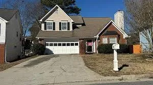Traditional style residence featuring a brick and siding exterior, an attached two-car garage, and a gabled roofline