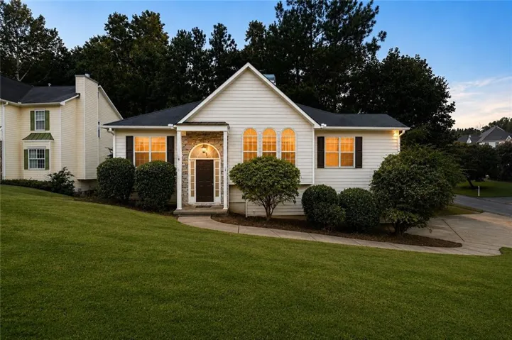 White siding exterior with a dark roof and decorative stone accents