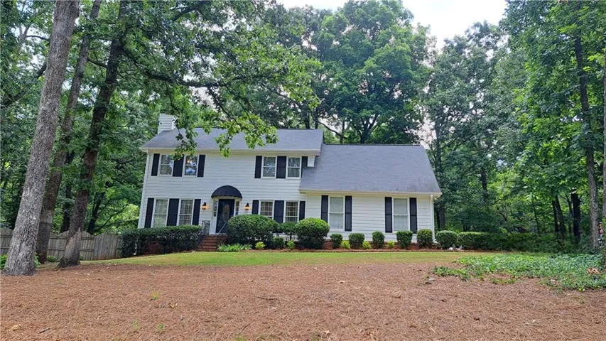 Traditional two-story residence with white siding and black shutters