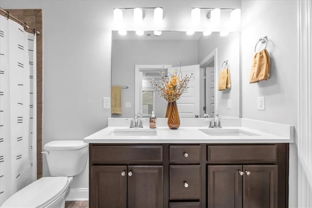 Full bath featuring double vanity and a shower with curtain