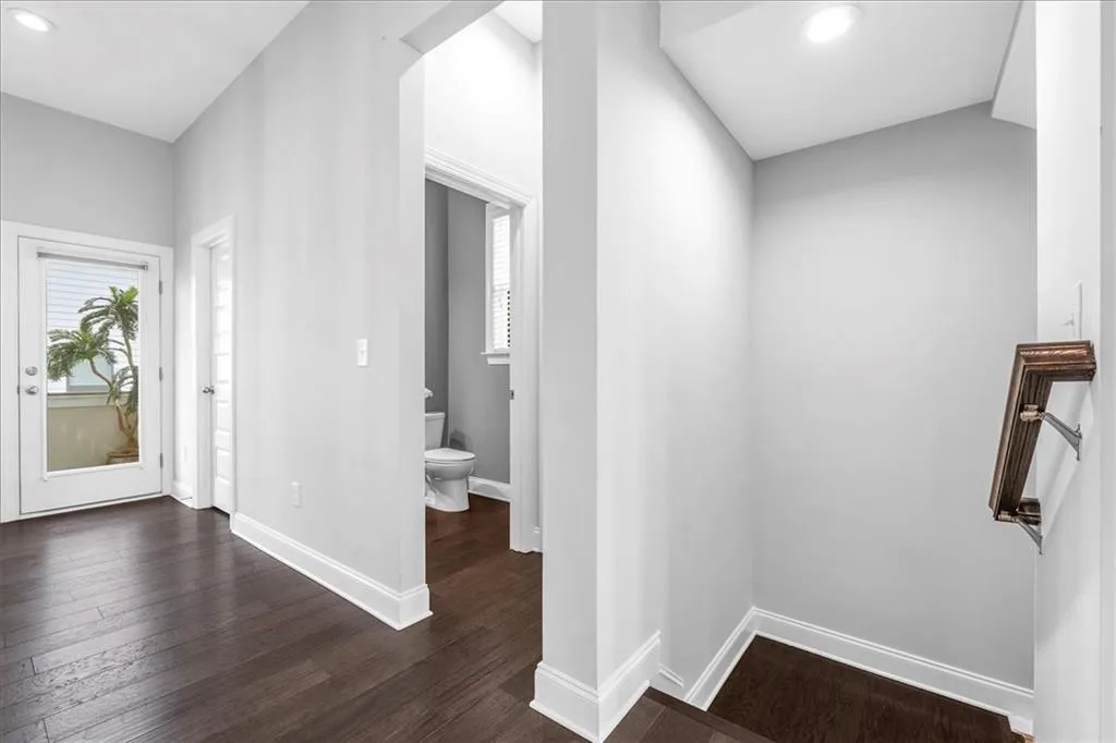 Hall featuring recessed lighting, dark wood-style flooring, and healthy amount of natural light