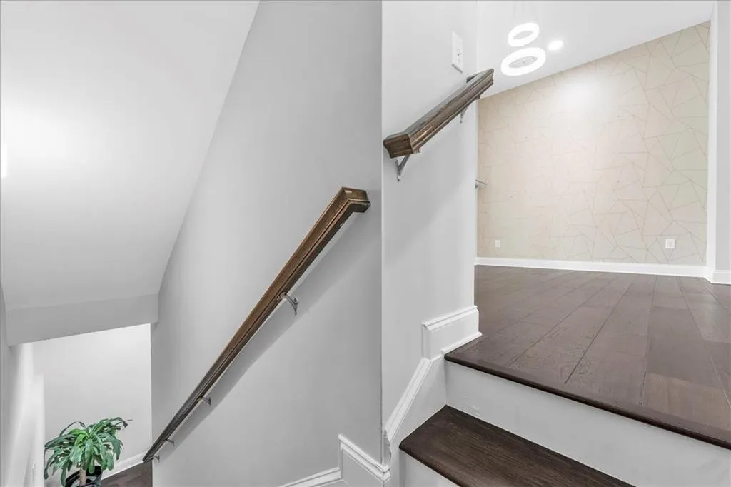 Stairs with wood finished floors and baseboards