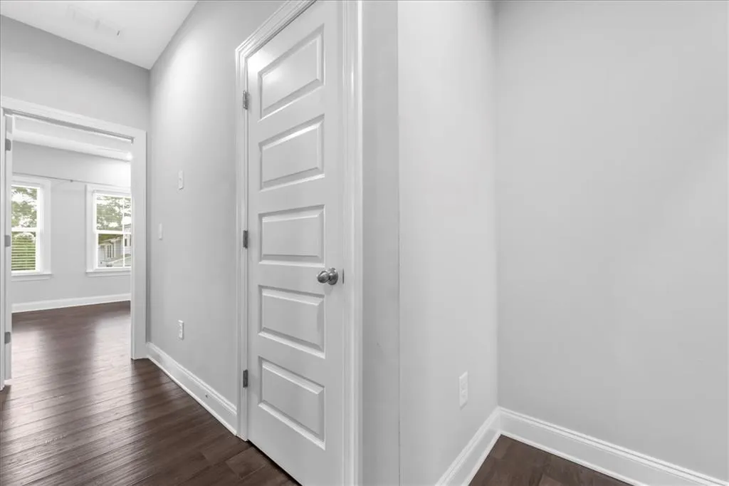 Hall featuring dark wood-type flooring and baseboards