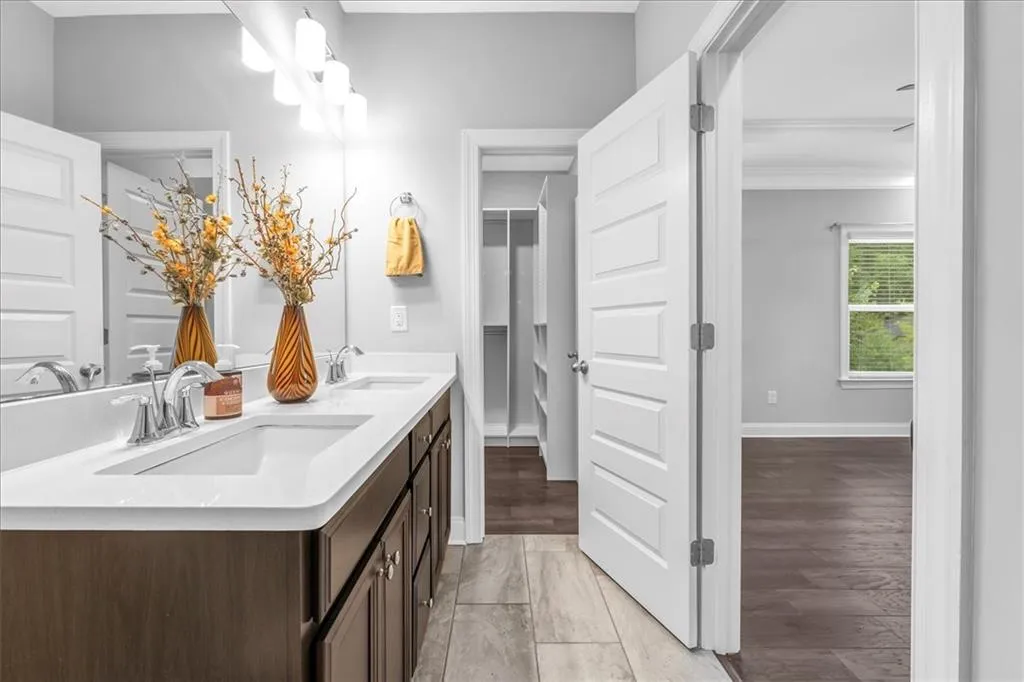 Bathroom with double vanity and baseboards