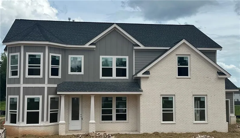 Two-story exterior with a combination of light-colored brick and horizontal siding