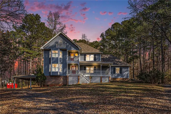 Traditional-style residence featuring a blue siding exterior, a multi-level front porch, white railings, and a prominent front staircase