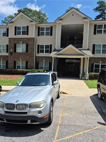 Multi-story building featuring tan siding and brick accents