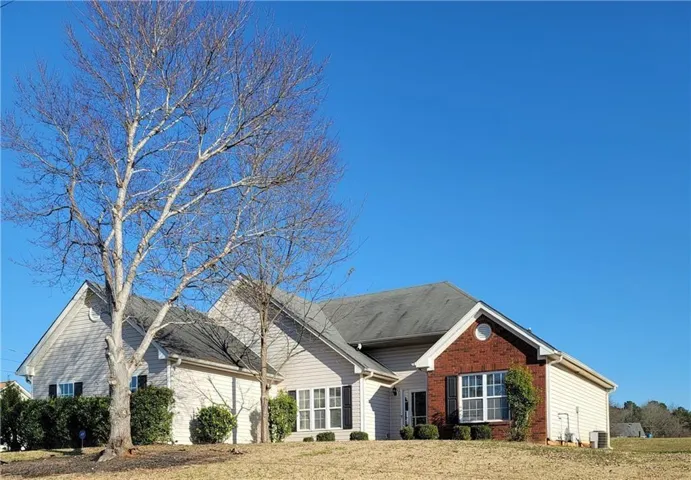 Ranch-style residence featuring a combination of light-colored siding and brick accents