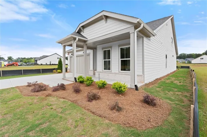 White siding exterior with brick veneer accent, covered front entry, and attached garage