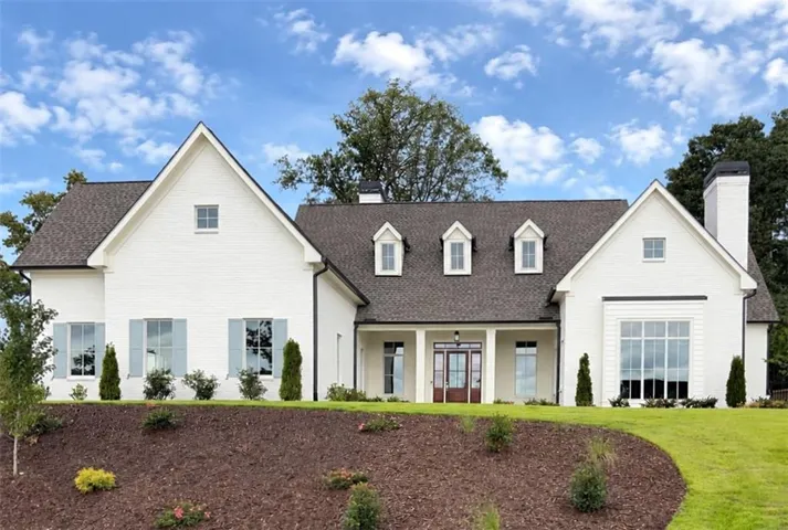 White brick exterior with a dark shingle roof
