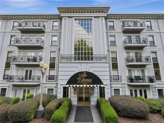 The James building exterior featuring a grand entrance with a black awning and ornate gold double doors