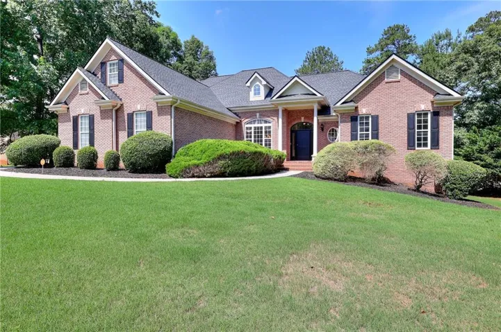 Brick exterior featuring architectural gables and a dark shingle roof