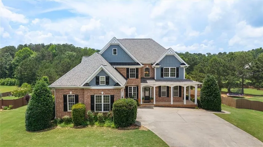 Brick and siding exterior with multiple gables, covered porch, and a concrete driveway