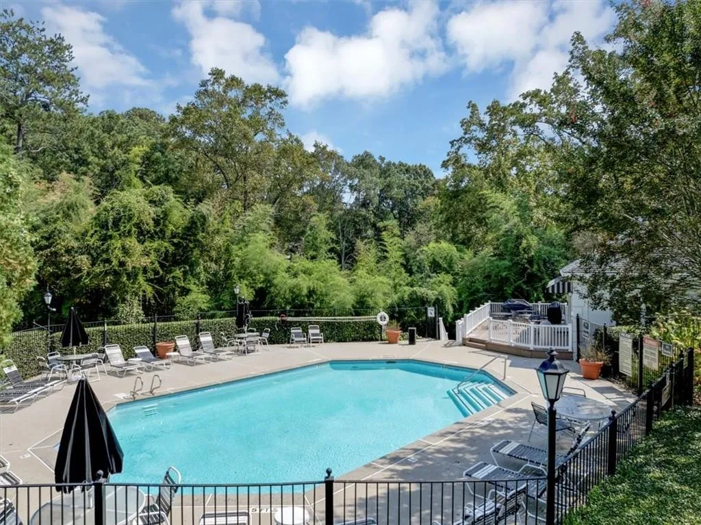 Community pool with a patio area and a wooden deck