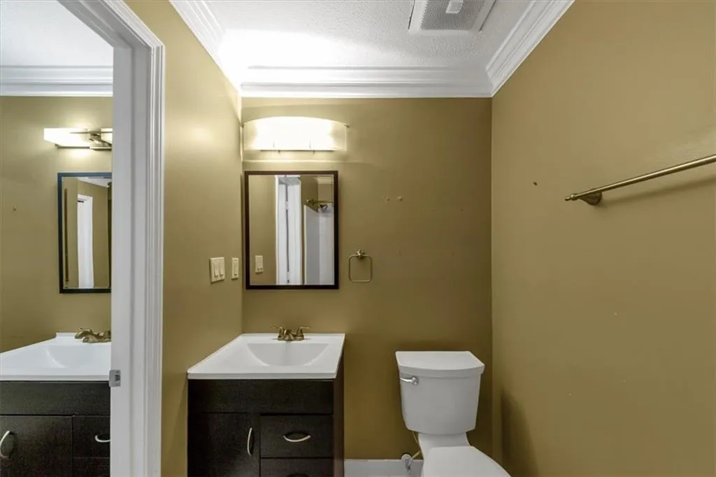 Bathroom featuring vanity, ornamental molding, and a textured ceiling