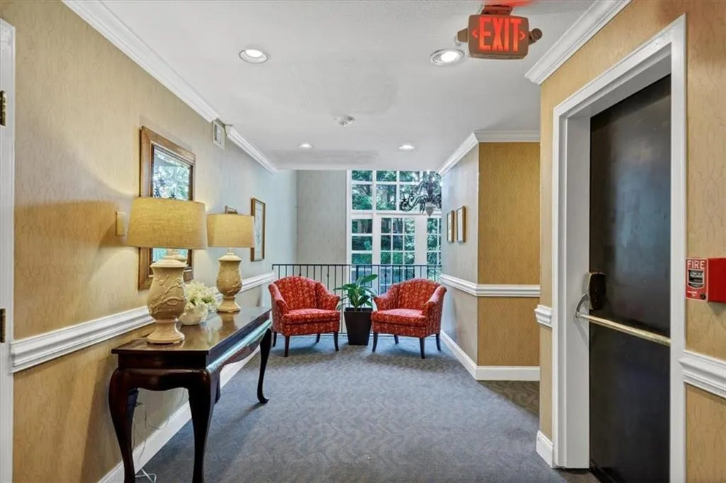 Living area featuring ornamental molding, wallpapered walls, carpet flooring, and recessed lighting