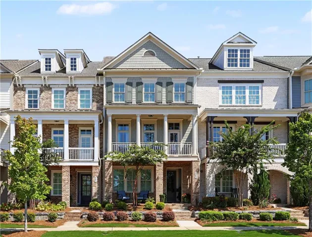 Brick and siding exterior featuring dormer windows and covered balconies