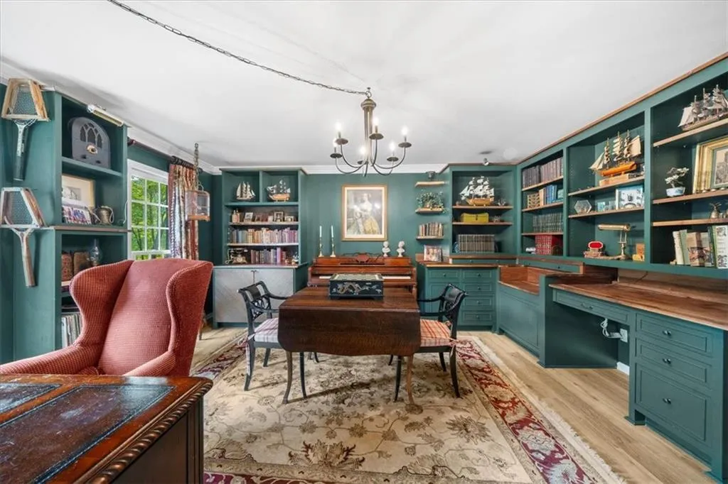 Office area featuring a chandelier, crown molding, light wood finished floors, and built in shelves