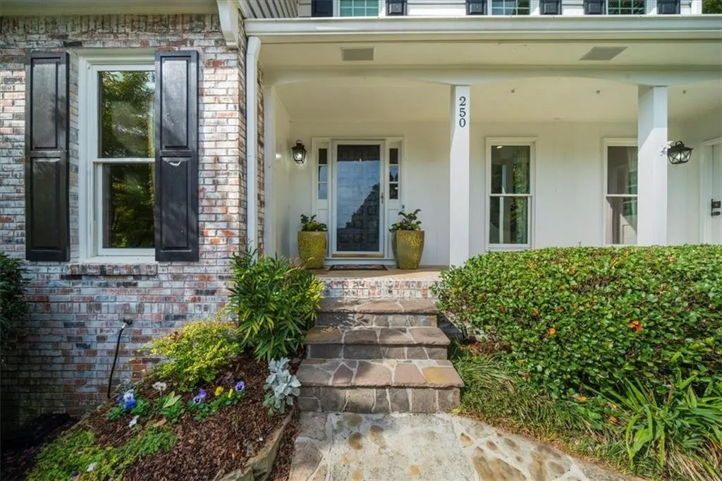 Property entrance featuring a porch and brick siding