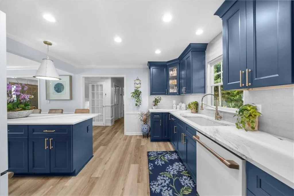 Kitchen with blue cabinets, pendant lighting, light wood-style flooring, white dishwasher, and recessed lighting
