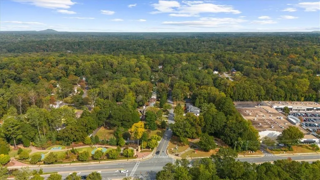 Aerial view of property and surrounding area with a heavily wooded area