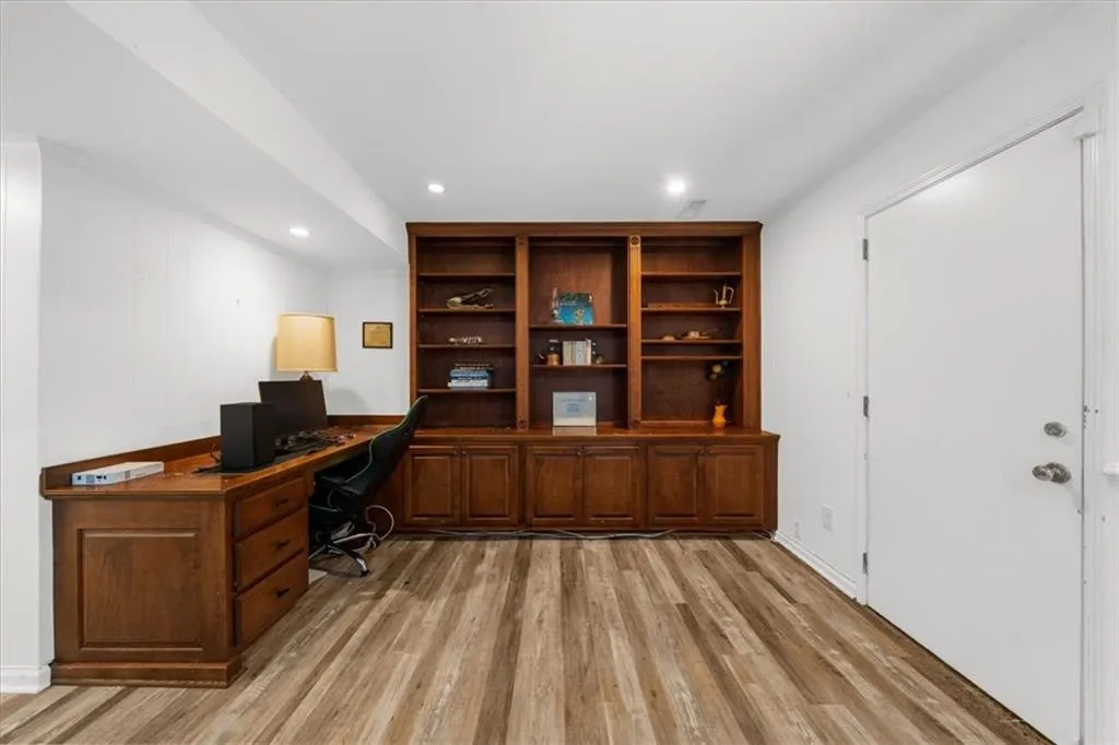 Office area with light wood-style flooring and recessed lighting