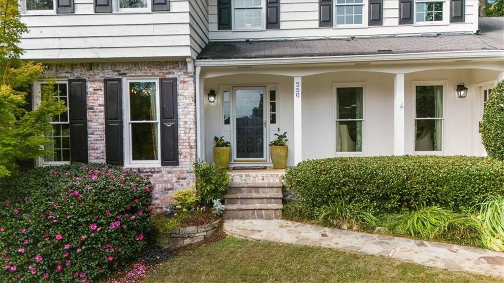 Entrance to property with covered porch and brick siding