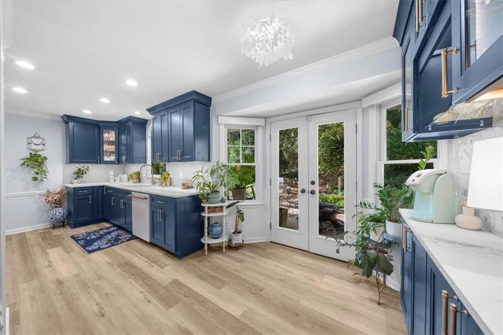 Bar featuring blue cabinetry, glass insert cabinets, crown molding, french doors, and tasteful backsplash