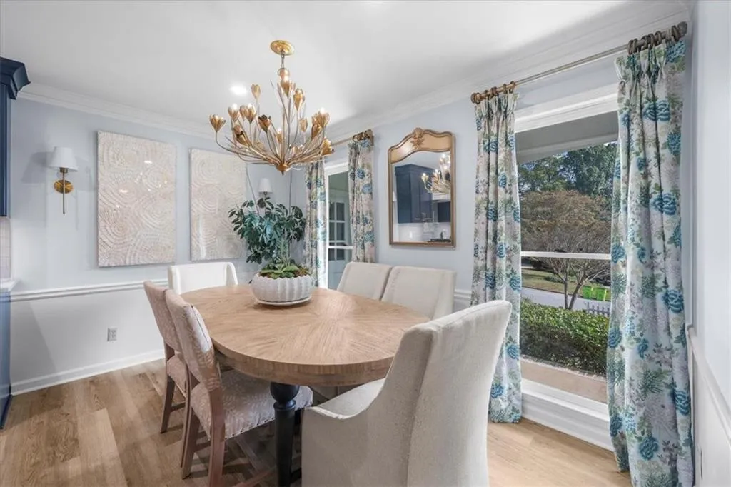 Dining room featuring ornamental molding, light wood-type flooring, and a chandelier