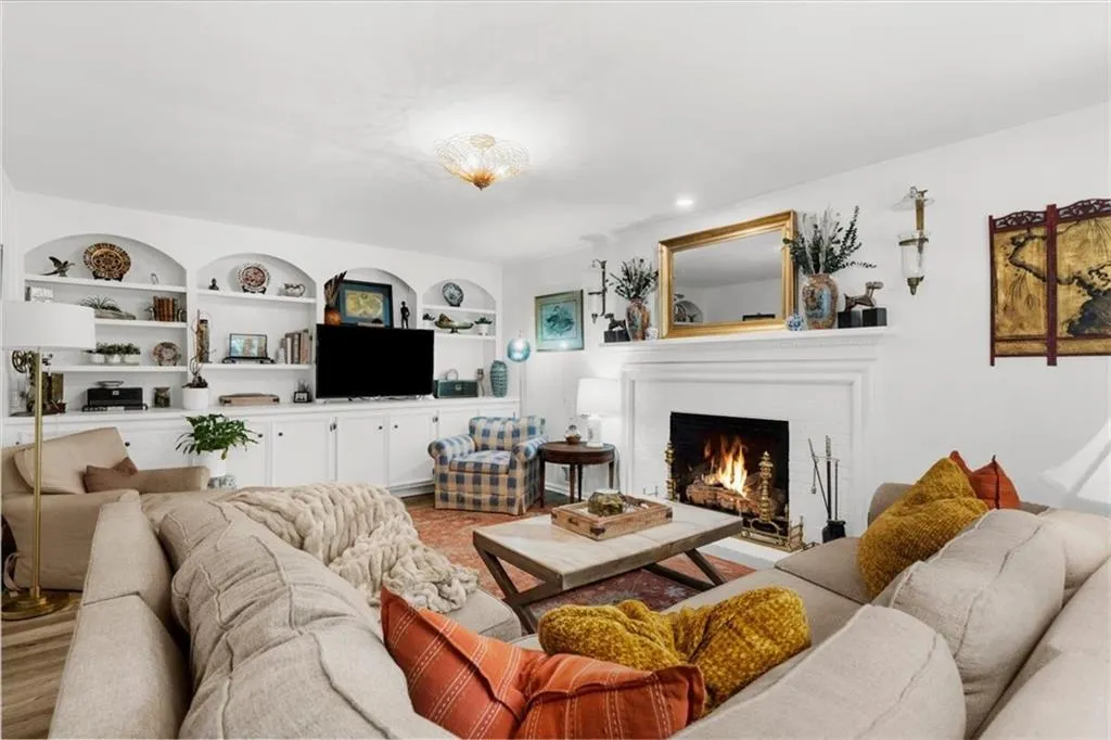 Living area with a fireplace and built in shelves
