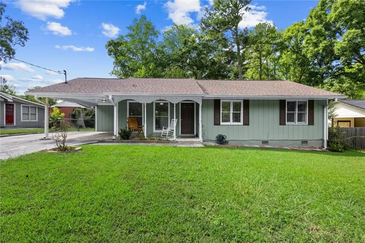 Light green siding exterior with a brown shingle roof