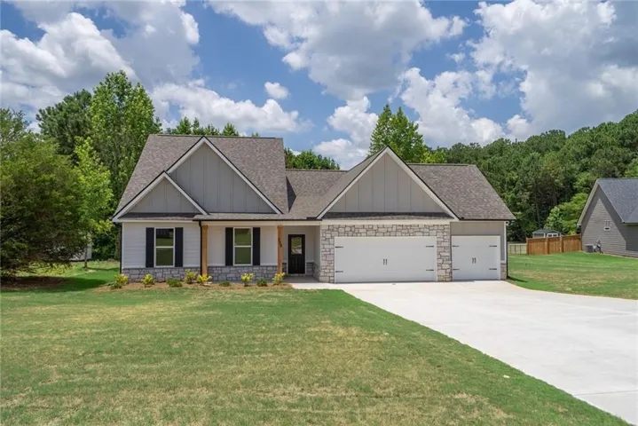 Single-story residence featuring light gray siding with stone veneer accents