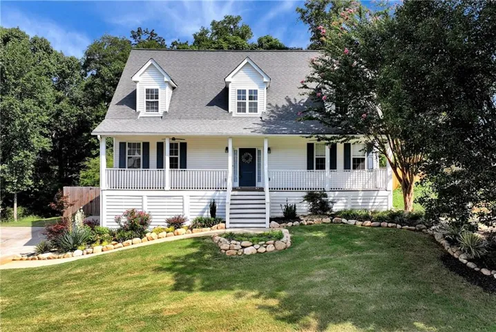 White siding exterior with a covered front porch featuring white railings