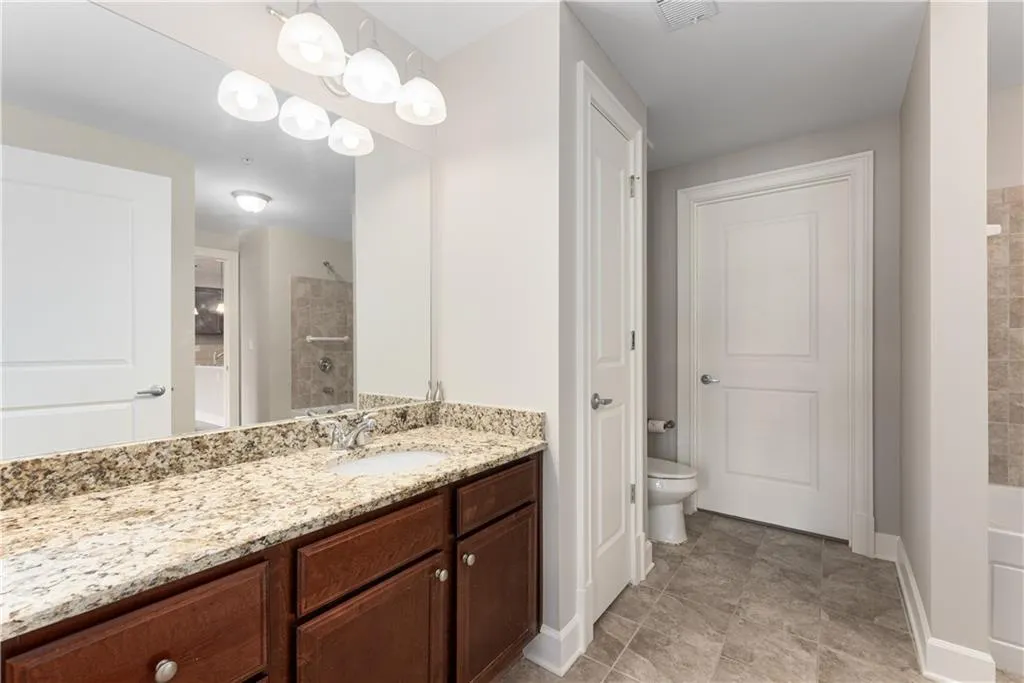 Bathroom featuring toilet, vanity, and walk in shower